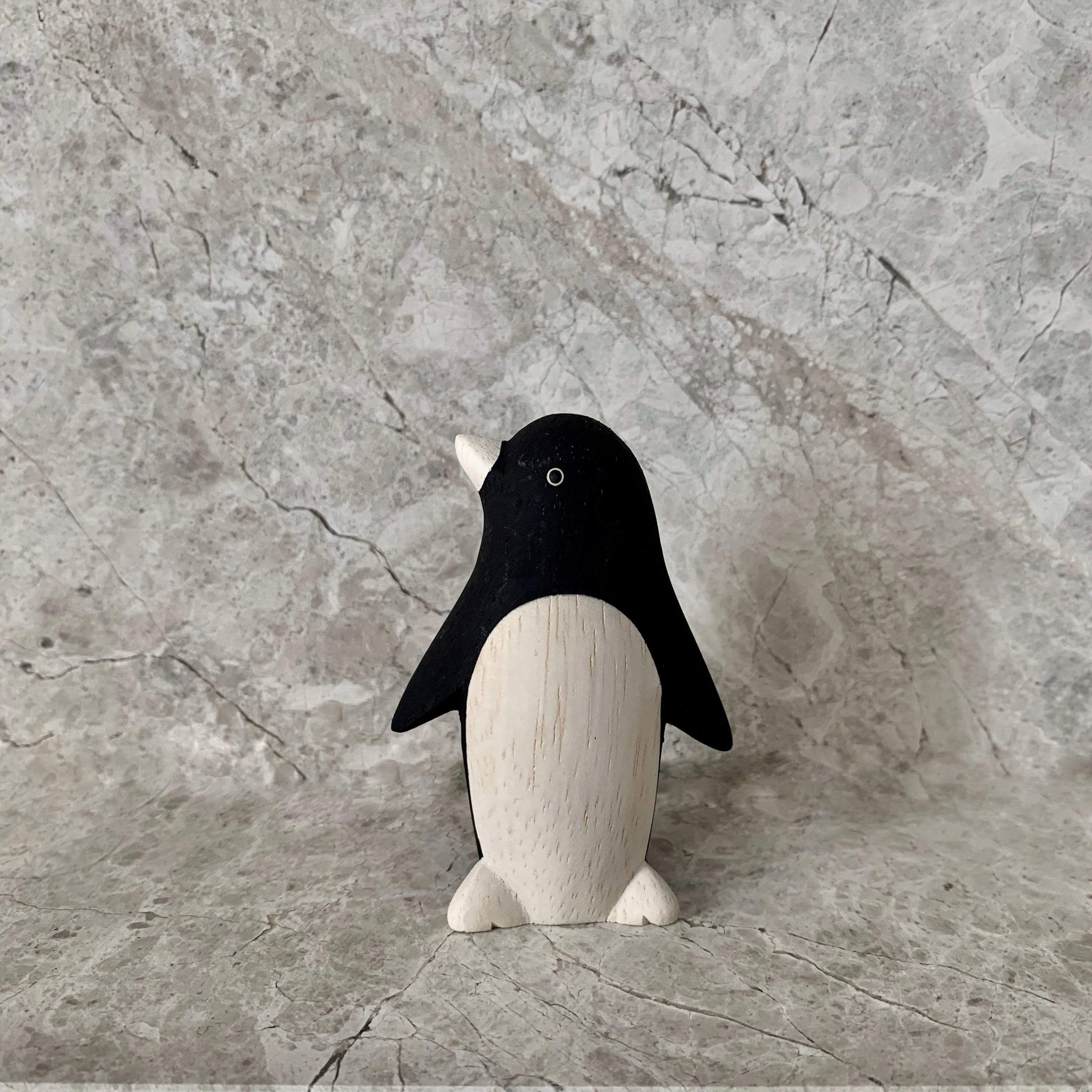 perfectly crafted wooden penguin toy with white belly and white nose 